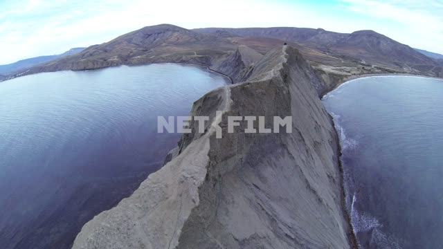 The camera flies over the sea and the Cape Chameleon. Koktebel, sea, mountain, altitude, drone,...