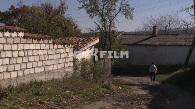 A man walks along the road in the village. Koktebel, road, bricks, house, fence.