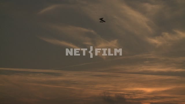 Man flying on a hang glider in the sky. Koktebel, hang gliding, flight, clouds, dawn.