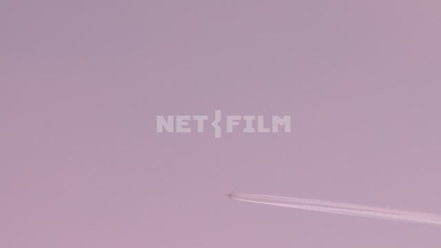 Самолет летит далеко в небе Коктебель, самолет, след, розовое небо, общий план, полет самолета.