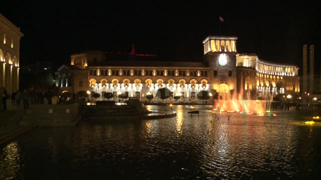 Люди гуляют по площади Республики у поющих фонтанов в Ереване....