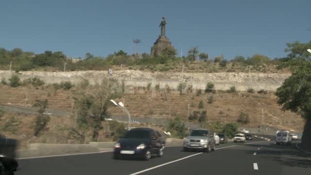 The view from the car on the road and the monument of Mother Armenia....