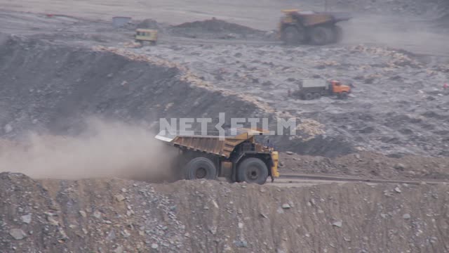 Dump truck BelAZ-75170 goes on the road in his career. Quarry dump truck, coal, slag heap, hill,...