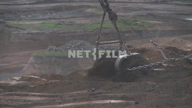 Backhoe bucket takes the ground. Transport, excavator, bucket, quarry, coal, boom, cables, chains,...