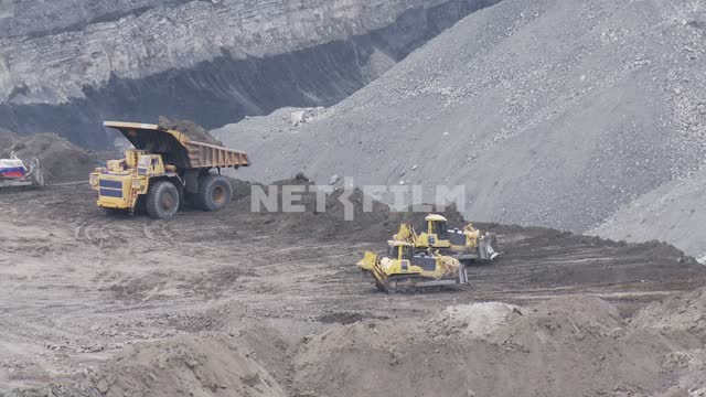 Caterpillar D7H bulldozers and dump Trucks BelAZ-75170 working in the quarry. Quarry, bulldozer,...