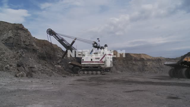 495HD Bucyrus excavator loads the rock body mining dump truck BelAZ-75170. Boom, bucket, ropes,...