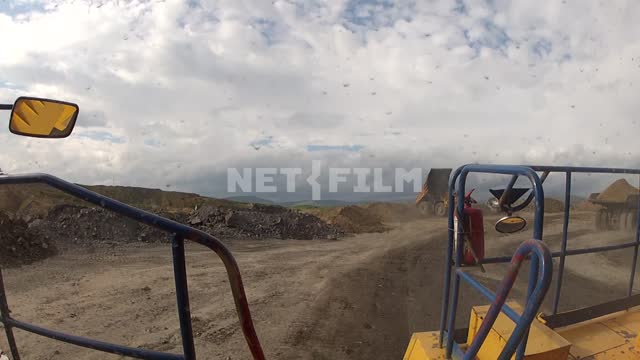 View of the road from a moving dump truck BelAZ-75170. Dump truck, quarry, soil, dust, road.