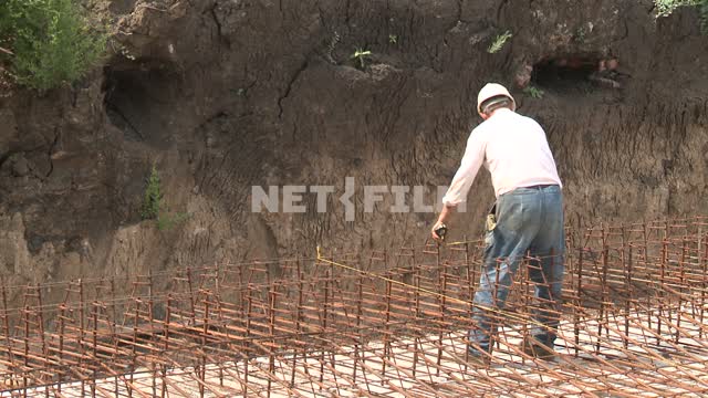 Worker on the construction site The excavation, rebar, wire mesh, working, building, slab,...
