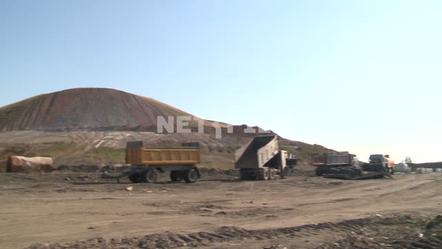 A truck and trailer on the backdrop of the slag heap. Waste heap, hill, mine, coal, dump, truck,...