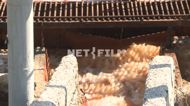 Wastewater flows through the concrete chute into the tank of the treatment plant. Gutter, drain,...
