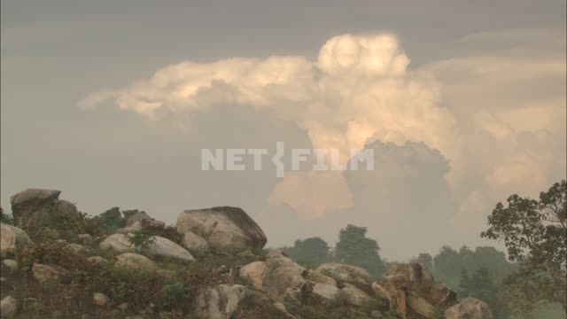 View of Cumulus clouds and stones. Clouds, rocks, boulders, trees.