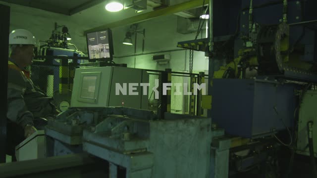 The operator at the machine, large metal parts are driven through the machine Plant, plant,...