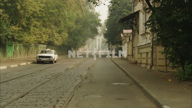 A taxi passes by on an empty street City, street, road, sidewalk, tram tracks, manholes, wooden...